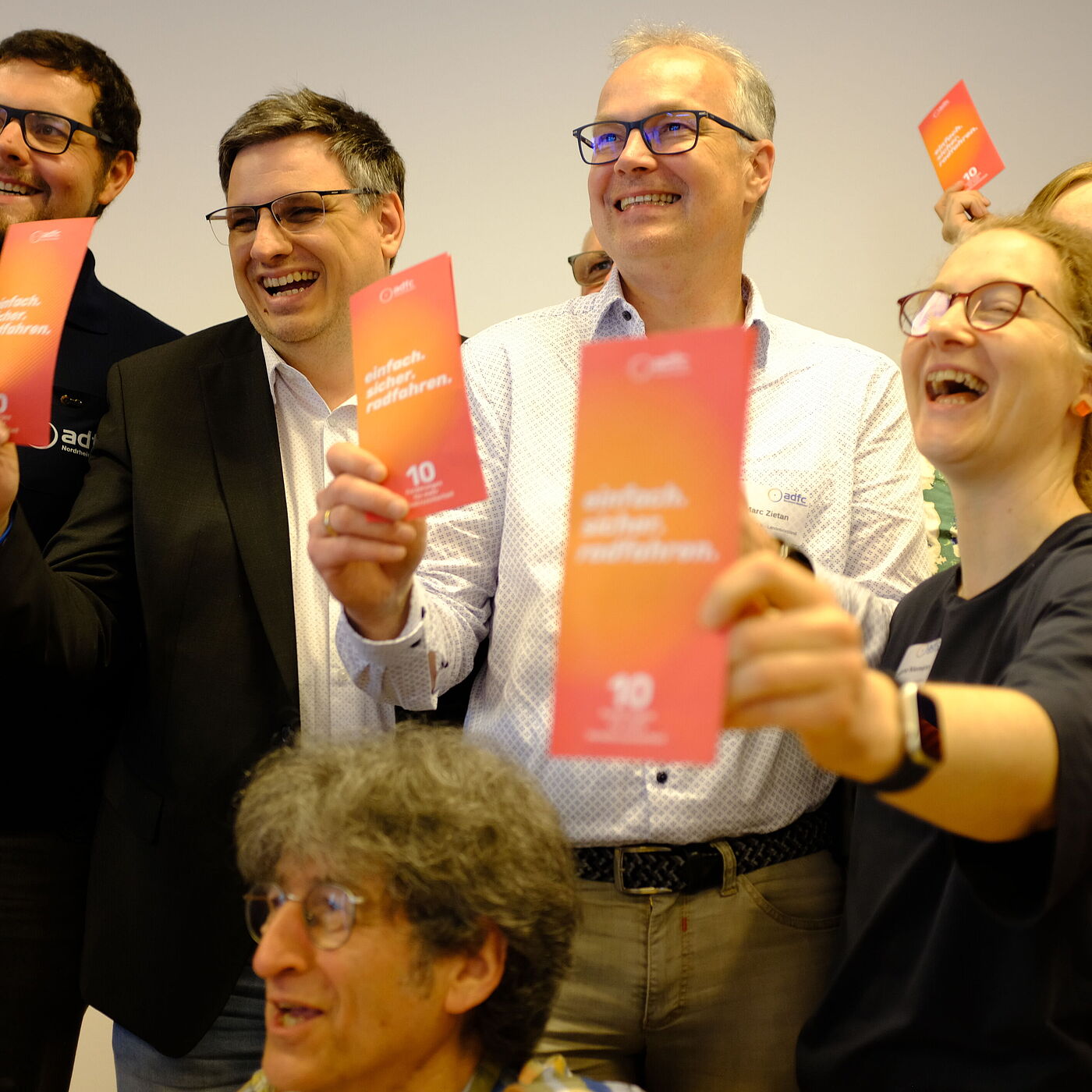 2026_04_18_Landesversammlung_Muenster_ADFC-NRW Vier Personen halten einen Kampagnenflyer hoch.