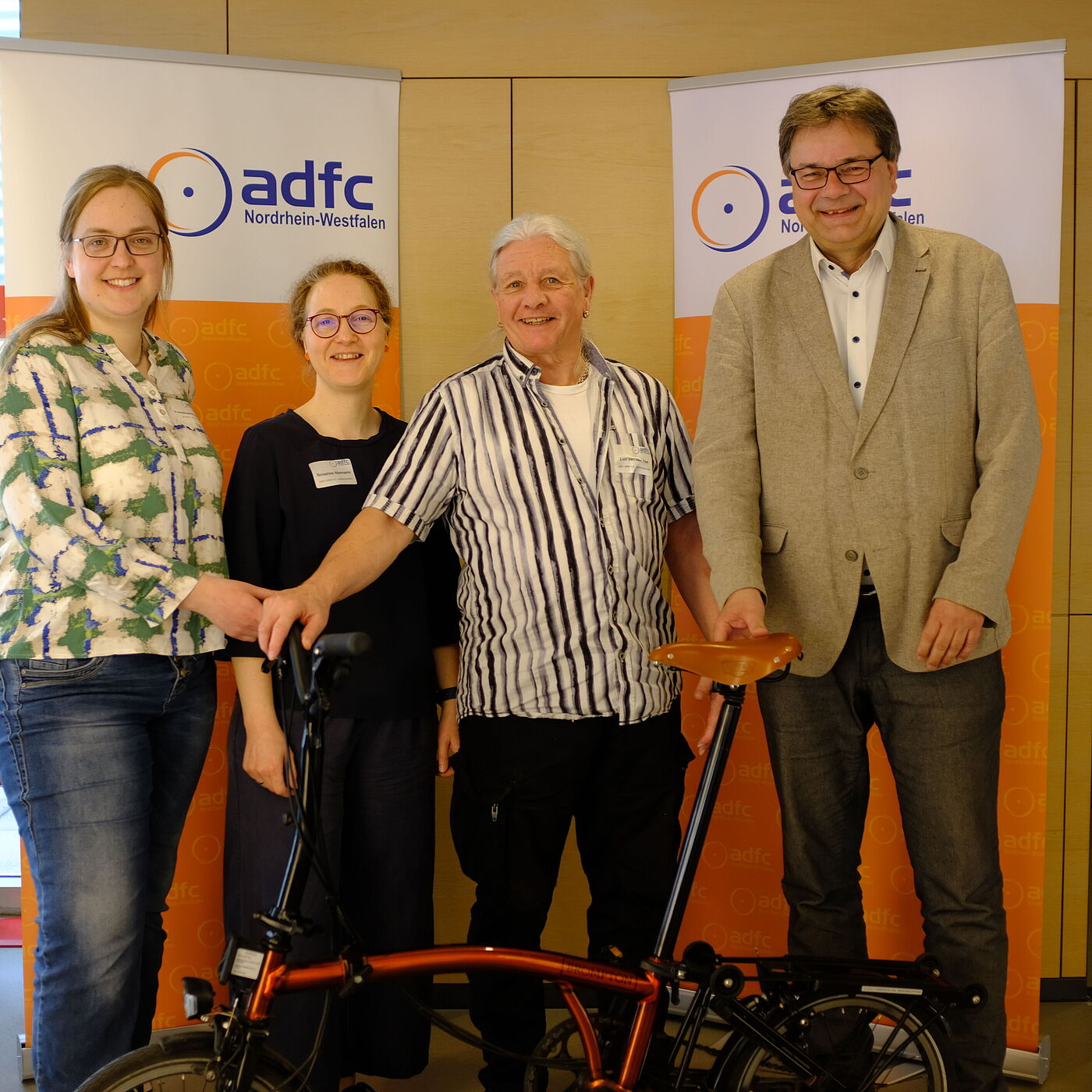 2026_04_18_Landesversammlung_Muenster_ADFC-NRW Vier Personen vor Roll-up.